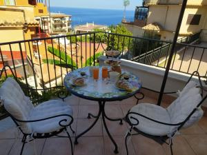 - une table avec de la nourriture et des boissons sur un balcon dans l'établissement Apartment Marifra Garden, à Taormine