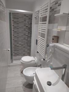 Baño blanco con 2 aseos y lavamanos en Apartment Marifra Garden, en Taormina