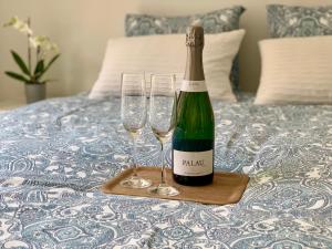 a bottle of wine and two wine glasses on a bed at Appartement Giulia in Knokke-Heist