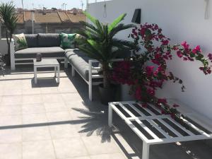 a patio with couches and a potted plant and flowers at Entremares in Lo Pagán