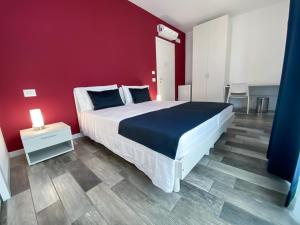 een slaapkamer met een groot bed en een rode muur bij Bonne Nuit Guest House in Azzano San Paolo