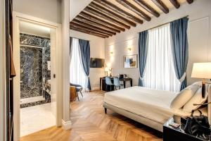 ローマにあるBabuino Palace&Suitesのベッドとデスクが備わるホテルルームです。