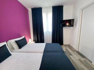 ein Schlafzimmer mit einem großen Bett mit einer lila Wand in der Unterkunft Bonne Nuit Guest House in Azzano San Paolo