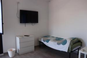 a bedroom with a bed and a flat screen tv at La Conchiglia 2.0 in Soverato Marina