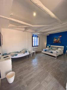 Zimmer mit 2 Betten und blauer Wand in der Unterkunft La Conchiglia 2.0 in Soverato Marina