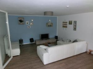 sala de estar con sofá blanco y TV en 2-Zimmer-Wohnung in Stralsunds Altstadt en Stralsund