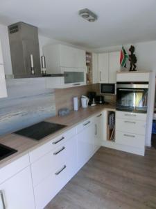 a kitchen with white cabinets and wooden floors at 2-Zimmer-Wohnung in Stralsunds Altstadt in Stralsund