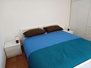 a bedroom with a bed with a blue blanket on it at Roby in Cascine