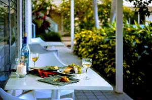 a table with a plate of food and two glasses of wine at Villa Venezia in Fort Lauderdale