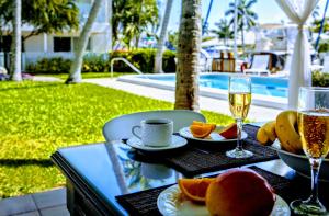 a table with a glass of wine and fruit on it at Villa Venezia in Fort Lauderdale