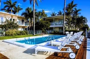 a pool with lounge chairs next to a building at Villa Venezia in Fort Lauderdale