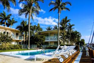 a resort swimming pool with lounge chairs and palm trees at Villa Venezia in Fort Lauderdale