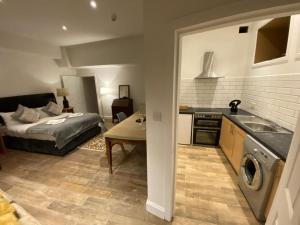 a kitchen and living room with a bed and a table at Queen Street Boutique Suites in Edinburgh