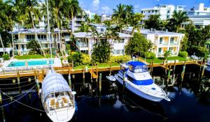 twee boten zijn aangemeerd in een jachthaven met gebouwen bij Villa Venezia in Fort Lauderdale