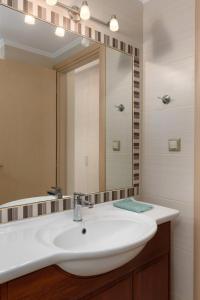 y baño con lavabo blanco y espejo. en Beach Front Condo South Crete en Kali Limenes