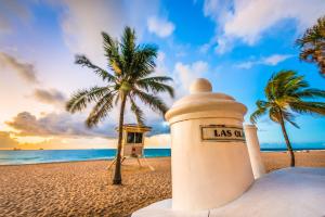 a lighthouse on the beach with a palm tree at Villa Venezia in Fort Lauderdale