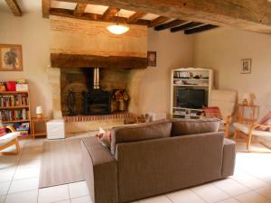 a living room with a couch and a fireplace at La Joie du Muguet Detached cottage Private heated swimming pool Shared Games room in Auverse