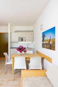 cocina y comedor con mesa y sillas en Condominio Lavinia, en Bibione