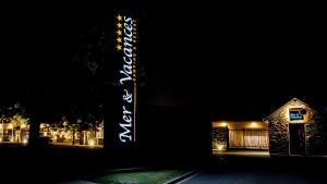 a sign that is lit up in front of a building at M&V Resort Camping in Langrune-sur-Mer