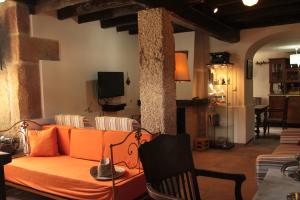 un soggiorno con divano arancione e sedia di Casa do Balcão ad Alcains