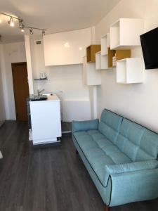 ein Wohnzimmer mit einem blauen Sofa und einer Küche in der Unterkunft Appartamenti Scrovegni in Padua