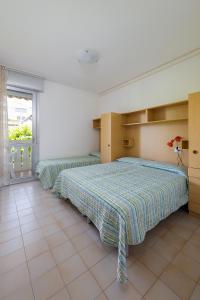 1 dormitorio con 2 camas y ventana en Condominio Lavinia, en Bibione