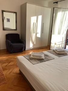 ein Schlafzimmer mit einem Bett und einem Stuhl und einem Fenster in der Unterkunft Apartment DAZ in Makarska