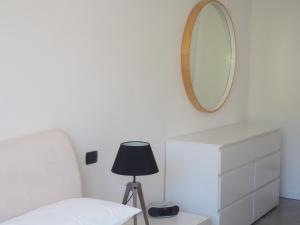 a white bedroom with a mirror and a white dresser at FairView in Bardolino