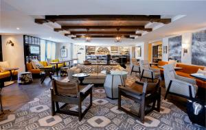 una sala de estar con sofás, mesas y sillas en Hotel Amarano Burbank-Hollywood, en Burbank