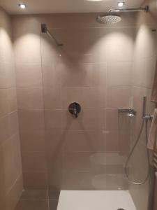 ein Bad mit einer Dusche und einer Glastür in der Unterkunft Hotel Krone in Bruneck