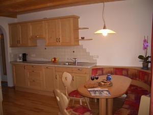 a kitchen with a table and a sink and a table and chairs at Lafreiderhof in Castelrotto +37 photos