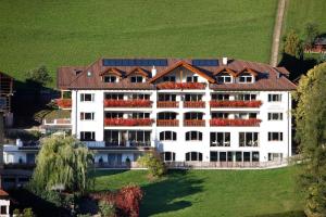ein großes weißes Gebäude mit braunem Dach in der Unterkunft Hotel Grones in St. Ulrich in Gröden