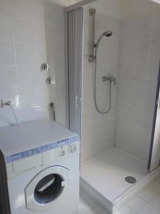 a bathroom with a washing machine and a shower at Soggiorno "Ulivi" in Altino
