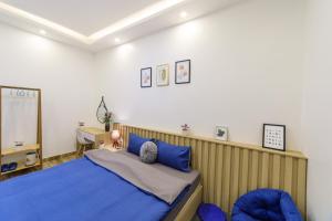 a bedroom with a blue bed and a desk at Minh Uyen Homestay in Da Lat