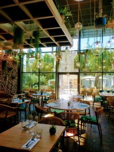 un restaurant avec des tables, des chaises et des fenêtres dans l'établissement Aquabella Hôtel & Spa, à Aix-en-Provence