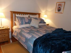 a bedroom with a bed with blue comforter and pillows at Maison Pierre D'Or in Sarlat-la-Canéda