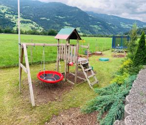 a playground with a swing and a house at Appartements Samerhof - TOP 1 in Kaltenbach