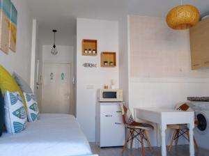 um pequeno quarto com uma cama, uma secretária e um lavatório. em Piso Pescaíto - Tarifa Centro em Tarifa