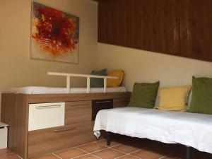 a room with two beds and a cabinet and a painting at Casa Montanyés in Conques