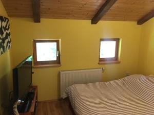 sypialnia z żółtymi ścianami, łóżkiem i 2 oknami w obiekcie Zebra w mieście Stegers