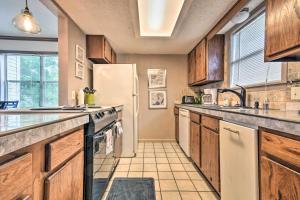 a kitchen with wooden cabinets and a white refrigerator at Family Resort Condo Near Lake with Boat Slip Access! in Hot Springs