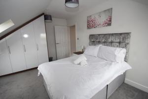 una camera da letto con un grande letto bianco con cuscini bianchi di Holden Court Apartment 5 a West Drayton