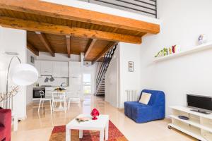 a living room with a blue chair and a table at Tenuta Giardini Nuovi in Novoli