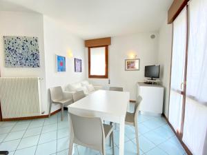 a living room with a white table and chairs at Villa Santin Carraro Immobiliare - Family Apartments in Lido di Jesolo