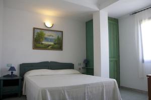 una camera con un letto e una foto appesa al muro di Casa Isidoro a Cala Liberotto