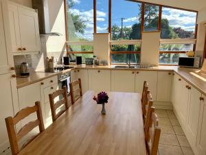 een keuken met een tafel met een vaas met bloemen erop bij The Old Bull Pen in Abergavenny