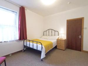 sypialnia z łóżkiem, oknem i drzwiami w obiekcie Carnation Flat A in Wembley w Londynie