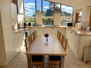 eine Küche mit einem Holztisch mit einer Vase mit Blumen darauf in der Unterkunft The Old Bull Pen in Abergavenny + 13 Fotos