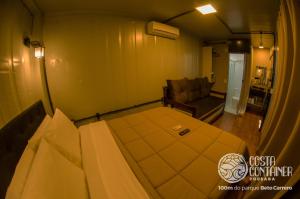 1 dormitorio con 1 cama y 1 sofá en una habitación en Pousada Costa Container en Penha