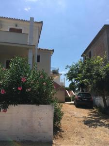 a car parked in front of a house with flowers at Georges Estates Hotel in Stoupa